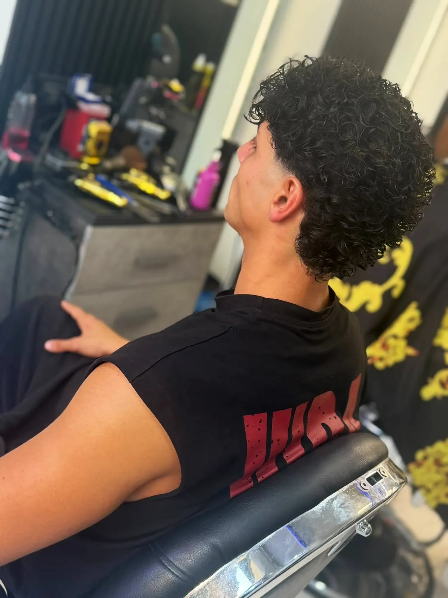 Mullet riccio con sfumatura alle tempie, taglio uomo da MOMOBARBER in Piazza Risorgimento 25, Seregno