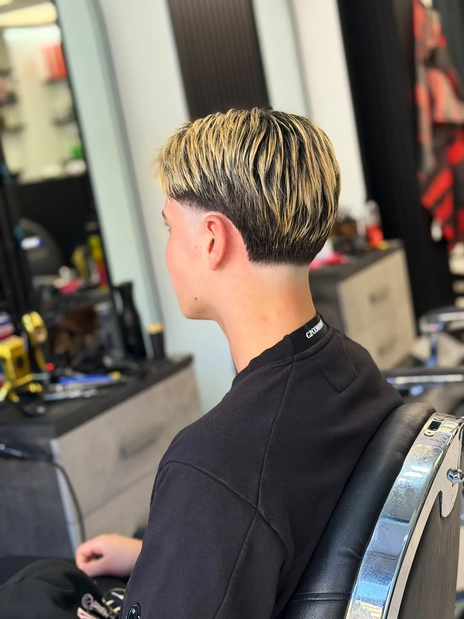 Taglio a scodella con mèches bionde e taper fade sulla nuca, da MOMOBARBER a Seregno